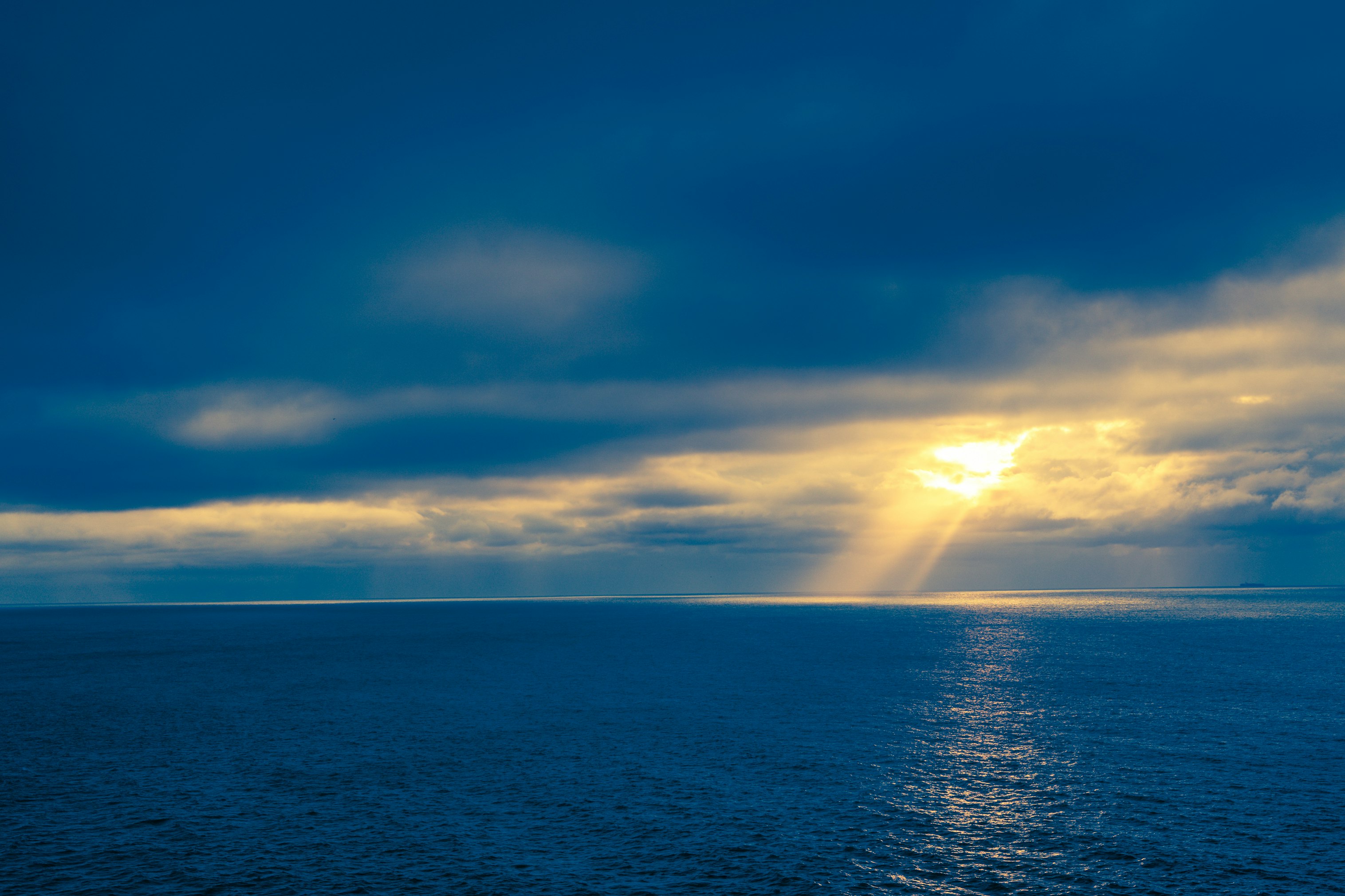 blue sea under blue sky and white clouds during daytime